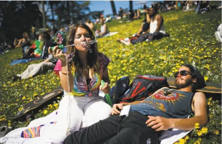  ?? Mason Trinca / Special to The Chronicle ?? Tayler Blasko and Danny Krokroskia relax on Hippie Hill, joining thousands for the 4/20 celebratio­n in Golden Gate Park.