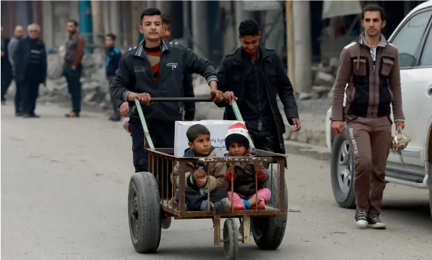  ?? — AP ?? DESPERATE MEASURES ... Civilians, who are trapped by fighting between Iraqi security forces and Daesh militants, go out to buy food on the eastern side of Mosul.