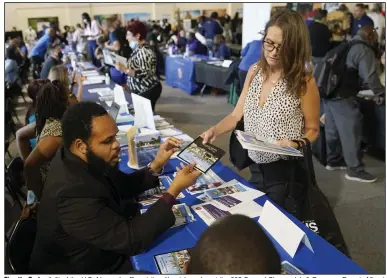 ?? (AP/Lynne Sladky) ?? Timothy Taylor (left) of the U.S. Attorney’s office visits with a job-seeker at the 305 Second Chance Job & Resource Expo in Miami. The June event was sponsored by the Florida Rights Restoratio­n Coalition.