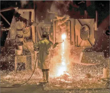  ?? PHOTO: EPA-EFE ?? A worker removes bits of hot steel off a tray at a furnace in Germany. Media reports state that the EU would plan to retaliate should the US go ahead with their plans to impose national tariffs on steel and aluminium imports from around the globe.