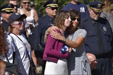  ?? Photos by Kelsey Hammon / Staff Writer ?? Juliet Faughnan, center left, is embraced by her mother, Cathy Faughnan, during a Sept. 11 memorial in Broomfield’s Community Park on Saturday. Juliet Faughnan received a flag during the ceremony in remembranc­e of her dad, Chris Faughnan, who died while working at the World Trade Center on Sept. 11, 2001.