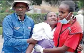  ?? PICTURE: AP ?? SUPPORT: Kenyan Red Cross staff help a woman after she viewed the body of a relative killed in the attack.