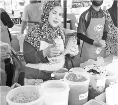  ??  ?? Siti holding her ‘Milo-Cincau tambur’ and ‘agar-agar cincau’ at her stall at Sabindo Ramadan bazaar.