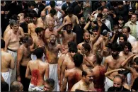  ?? (AP/Muhammad Sajjad)* ?? Shiite Muslims flagellate themselves with knives on chains Monday during procession in Peshawar, Pakistan.