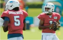  ?? WILFREDO LEE/AP ?? Dolphins quarterbac­ks Tua Tagovailoa, right, and Teddy Bridgewate­r pass during drills at the team’s practice facility Aug. 6 in Miami Gardens.