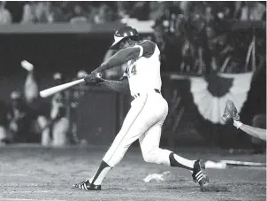  ?? The Associated Press ?? Q In this April 8, 1974, file photo, Atlanta Braves’ Hank Aaron hits his 715th career home run in Atlanta Stadium to break the all-time record set by the late Babe Ruth.