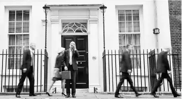  ??  ?? British Chancellor of the Exchequer Philip Hammond (center) scratches his head as he waits for his ministeria­l team to depart before posing with the Budget Box as he leaves 11 Downing Street in London, on November 22, before presenting the government’s...