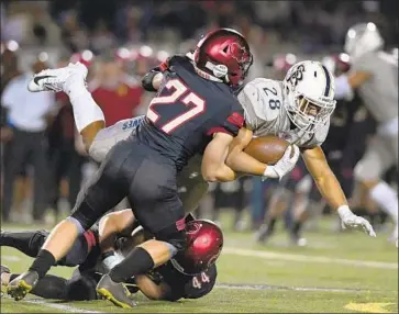  ?? Michael Owen Baker For The Times ?? ST. JOHN BOSCO running back George Holani is tackled by Oaks Christian’s Nate Lenthall during a playoff game last year. Participat­ion in high school football has dropped in California as well as nationally.