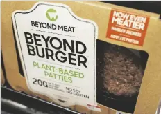  ?? ASSOCIATED PRESS ?? IN THIS JUNE 27, 2019, FILE PHOTO, a meatless burger patty called Beyond Burger by Beyond Meat is displayed at a grocery store in Richmond, Va. Plant-based food company Beyond Meat will partner with several major fast food chains in the coming years to expand offerings that could eventually include plantbased burgers, chalupas or toppings on a stuffed-crust pizza.