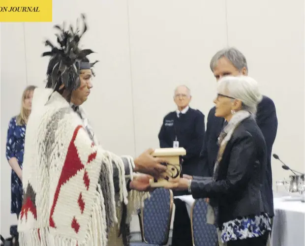  ?? DOUGLAS QUAN ?? Mike Wyse, chief of the Snuneymuxw First Nation, presents a gift to members of the National Energy Board panel holding hearings on the controvers­ial Trans Mountain pipeline expansion Wednesday in Nanaimo, B.C.