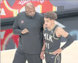  ?? KEVIN C. COX — GETTY IMAGES ?? Hawks coach Nate McMillan chats with Trae Young, averaging 29.1 points in the playoffs.