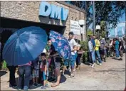  ?? Kent Nishimura Los Angeles Times ?? PEOPLE line up outside a Department of Motor Vehicles office in South Los Angeles on Tuesday.