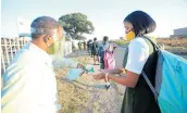  ??  ?? SAFETY FIRST: A John Bisseker High School Grade 12 pupil gets her hands sanitised on the way back to class. Good hygiene is being drummed into all pupils across the nation.