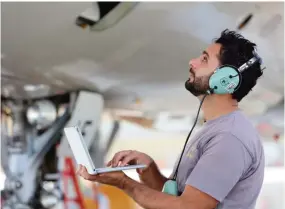  ??  ?? An Etihad Airways engineer carries out a maintenanc­e check on an aircraf