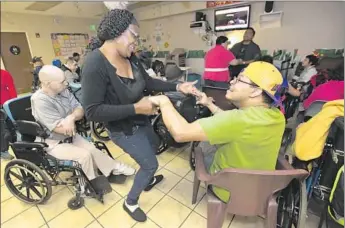  ?? Photograph­s by Mel Melcon
Los Angeles Times ?? VALLEY VILLAGE , which provides care for people with developmen­tal disabiliti­es, says it supports the idea of a raise even though its payroll costs would soar. Above, aide Alice Jackson dances with a client.