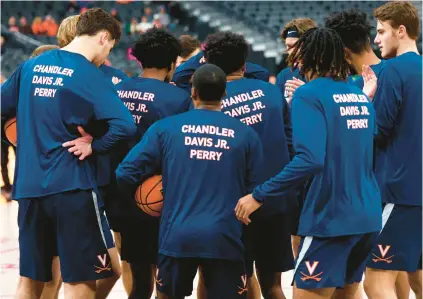  ?? CHASE STEVENS/AP ?? Virginia basketball players wear warmup shirts Friday night in memory of the three Cavaliers football players killed in a shooting last Sunday. The No. 16 Cavaliers knocked off No. 5 Baylor 86-79.