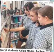  ?? ?? Year 6 students Kailee Moore, Ashlynn Connors and Charlotte Russo browse the shelves of the Book Fair.