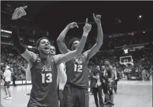  ?? The Associated Press ?? NOT DONE YET: Nevada guard Hallice Cooke (13) and forward Elijah Foster (12) celebrate the team’s 22-point comeback in the second round of the NCAA Tournament Sunday against No. 2 seed Cincinnati. The Wolf Pack trailed, 65-43, with 10:48 left in the...