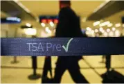  ?? Joe Raedle / Getty Images ?? Travelers go through a TSA PreCheck line in Miami. More data problems are popping up with PreCheck.