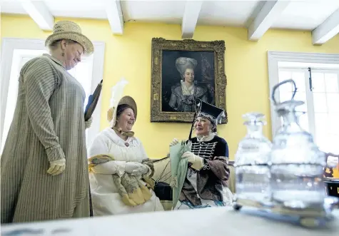  ?? JULIE JOCSAK/STANDARD STAFF ?? Women dressed as officers’ wives share a laugh while in the officers sitting room at Fort George. Re-enactors dressed as officers treated Fort George visitors Saturday to a living vignette of what an officer’s life was like within the fort during the...