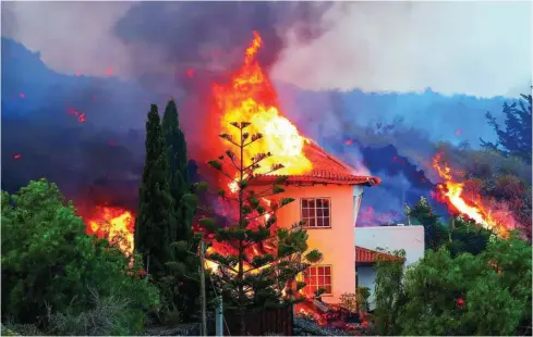  ?? REUTERS ?? Una de las viviendas afectadas por la lava del Cumbre Vieja, ardía ayer en llamas