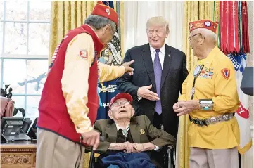  ??  ?? Trump greets Navajo veterans in the Oval Office of the White House during an event honouring Native American code talkers who served in World War II in Washington, DC. — AFP photo