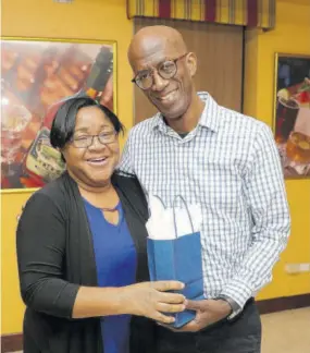  ??  ?? Clement ”Jimmy” Lawrence, chairman, J Wray &amp; Nephew Limited, makes a presentati­on to Claudette Brown during a luncheon in honour of the company’s EHS volunteers, at its Hospitalit­y Room, Spanish Town Road, recently.