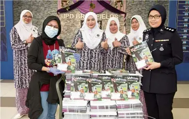  ??  ?? For the kids: Sharifah Thuraizah (left) posing with Perkep members with the Kuntum magazines donated atIPd Brickfield­s in Kuala Lumpur.