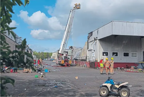  ?? Pictures: Steven Brown. ?? Firefighte­rs at the scene of the blaze which destroyed two large buildings at Southfield Industrial Estate.