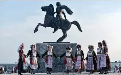  ?? —AFP ?? THESSALONI­KI, Greece: Dancers wearing traditiona­l costumes perform in front of the statue of Alexander III of Macedon, commonly known as Alexander the Great, on Tuesday.
