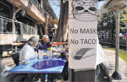  ?? Eric Gay The Associated Press ?? A sign requiring masks is posted near dining tables Wednesday in San Antonio. Texas’ mask mandate is set to end next week.
