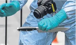  ?? PA. ?? A forensics officer recovers a knife from the scene.