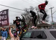  ?? GETTy imagES ?? OUTRAGE: Protesters jump on top of a police car as they clash after an officer shot and killed a Black man in Brooklyn Center, Minn., on Sunday.
