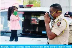  ?? — AFP ?? NAGPUR, India: Guinness world record holder of the world’s smallest living woman Jyoti Amge greets a police officer as she appeals citizens to stay inside their homes on Monday.