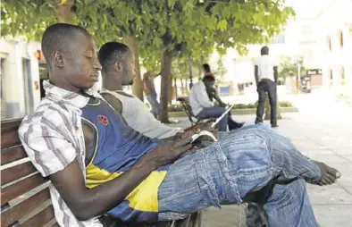  ?? EL PERIÓDICO ?? Unos inmigrante­s sentados en la plaza de La Almunia de Doña Godina.