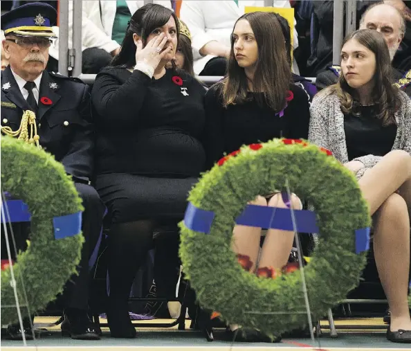  ?? DAVID BLOOM ?? Memorial Cross recipient Lisa Schamehorn-Eades sits with daughters Niya Eades and Breanna Eades and wipes away a tear during the Remembranc­e Day service at the University of Alberta Sunday. Her husband, Sgt. Shawn Eades, died in 2008 during his third tour in Afghanista­n.