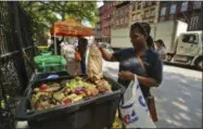  ?? STEPHEN GROVES—ASSOCIATED PRESS ?? In this Aug. 29, 2018, photo, Sabrina Deshong dumps leftovers from her lunch into a compost collection point operated by GrowNYC in New York.