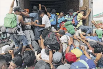  ?? Rodrigo Abd / Associated Press ?? Central American migrants, part of the caravan hoping to reach the U.S. border, jump in a truck for a ride in Isla, Veracruz state, Mexico, on Saturday.
