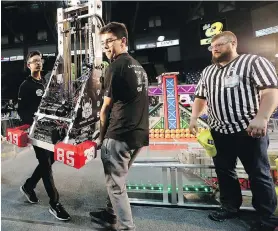  ??  ?? Shaan Mughal, left, and Jordan Di Raddo with Montreal’s Team Sonic Howl carry their robot onto the field during the Canadian Pacific Regional First Robotics Competitio­n at Save-on-Foods Memorial Centre on Thursday.