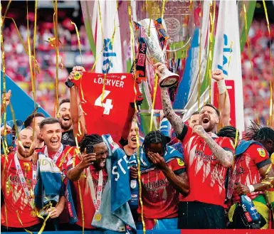  ?? Photo: AP ?? Luton Town’s Sonny Bradley lifts the trophy after winning the Championsh­ip play-off final against Coventry City at Wembley Stadium.