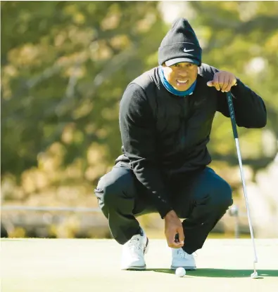  ?? CLIFF HAWKINS/GETTY ?? Tiger Woods lines up a putt during Wednesday’s Genesis Invitation­al Pro-Am. He will make his season debut Thursday.