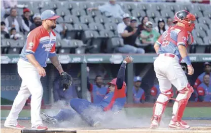  ?? AP ?? Frank Morel, de los Alazanes de Granma, se desliza entre Joe Colón y Jonathan Moral, de Criollos de Caguas, ayer martes durante un juego de la quinta jornada de la Serie del Caribe.