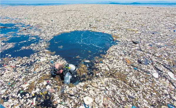  ??  ?? Instead of pristine Caribbean sea, a diver finds himself floating through a thick blanket of plastic waste near the Cayos Cochinos marine reserve off Honduras