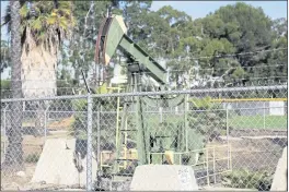  ?? HUNTER LEE — THE ORANGE COUNTY REGISTER VIA AP ?? An oil rig sits by the fields at the Wilmington Boys & Girls Club in Wilmington.