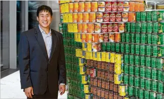  ?? JASON BUCH ?? Chris Yueh shows off “Hunger on my Mind,” one of the canned food art displays now showing at Atlantic Station. Yueh is committee chair of Canstructi­on Atlanta 2017, an art competitio­n to benefit the Atlanta Community Food Bank. Yueh says the...