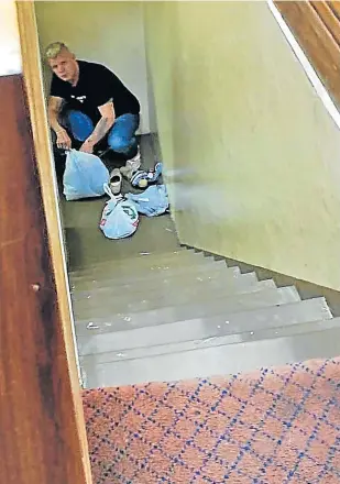  ?? Picture: NOMAHLUBI JORDAAN ?? LONG ROAD UP: Andrew Turnbull kneels at the bottom of the stairs with his possession­s in plastic bags on the way to the holding cells at the Randburg magistrate’s court on Wednesday.