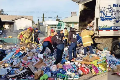  ??  ?? BoMBERoS Y empleados buscan a la víctima entre los desperdici­os