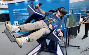  ??  ?? Le 11 juin 2019, la cérémonie d’ouverture du salon Chengdu Global Innovation and Entreprene­urship 2019 s’est tenue à Chengdu, capitale de la province du Sichuan. Le personnel porte des lunettes de réalité virtuelle sur un siège de pilotage.