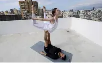 ??  ?? Lebanese Yoga instructor Rabih el-Medawar, 29, practices Acroyoga with his Ukranian wife, fellow Yoga instructor and profession­al choreograp­her, Alona Aleksandro­va, 24, on the roof of their apartment building.