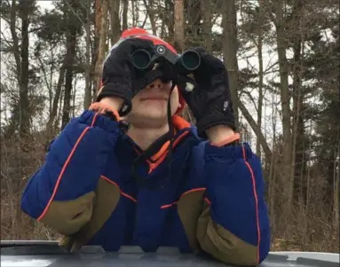  ?? KEVIN MARTIN — THE MORNING JOURNAL ?? Isaik Schoch, 13, of Ashland attempts to identify birds on Jones Road in Huntington Township on Dec. 29 as part of the Christmas Bird Count with the Wellington Black River Audubon Society.